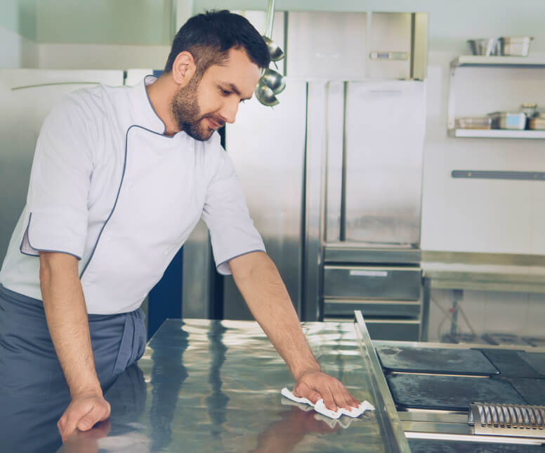 Professional cleaner using a cleaning solution to clean a countertop